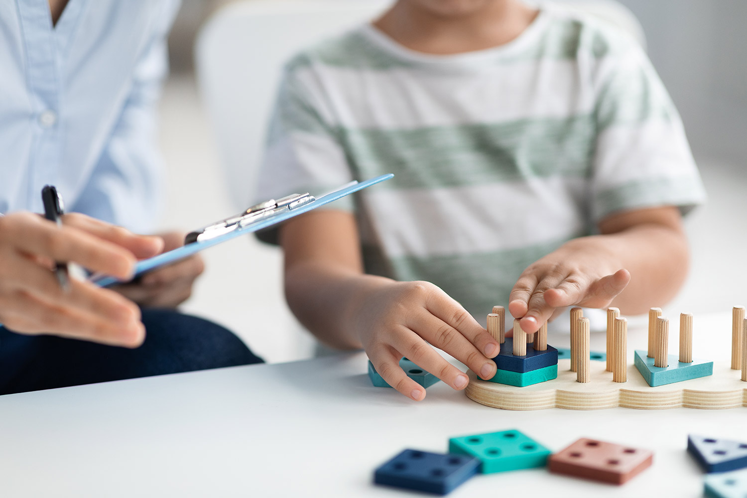 Little boy playing with wooden puzzle toys